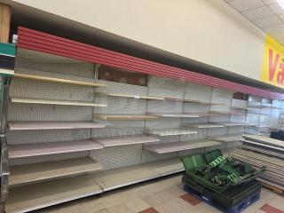 Single sided gondola shelving, 26 feet long, featuring multiple adjustable shelves. Condition shows wear. Buyer must remove.