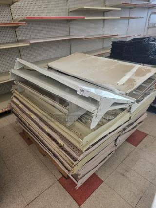 Four pallets of gondola shelving and miscellaneous parts, stacked in a room. Item number tag visible. Used condition.