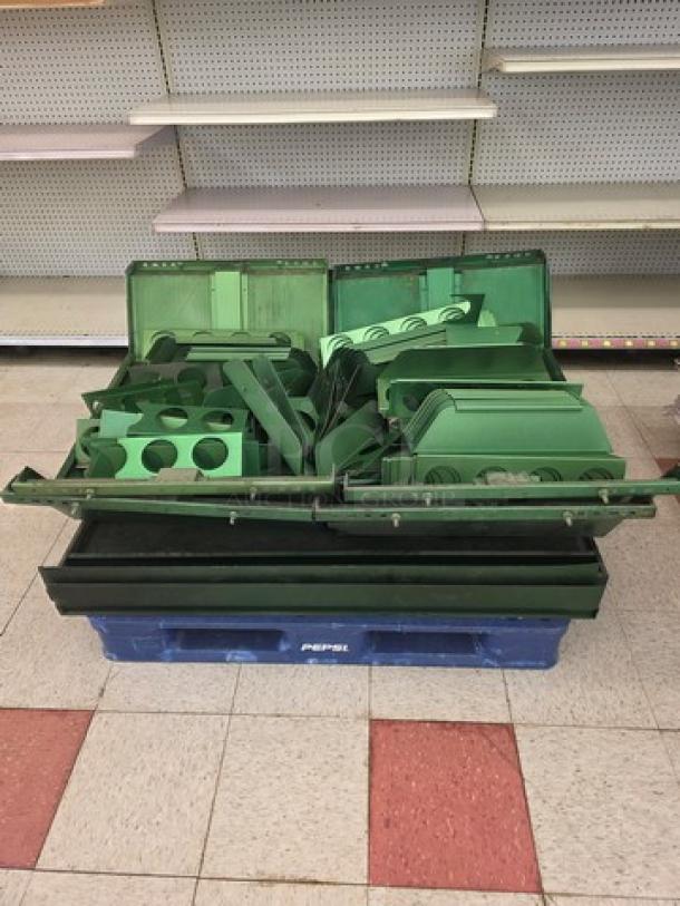 Four pallets of green gondola shelving and miscellaneous parts, stacked on a blue pallet. Components in used condition.