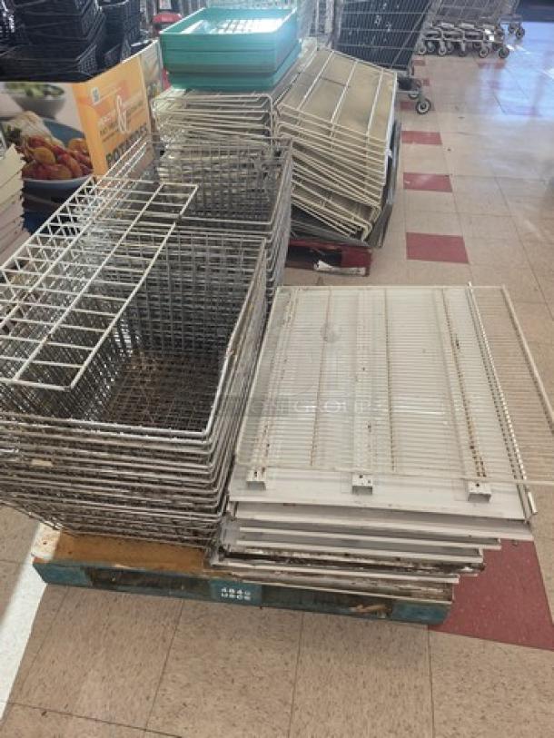 Four pallets of gondola shelving and miscellaneous parts. Includes metal shelves and baskets, suitable for retail display use.