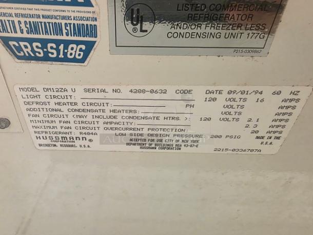Hussmann DM12ZAU Dairy Case label showing model, serial number 4208-0632, voltage, amps, and refrigerant R404A details.