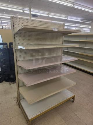 Gondola shelving unit with adjustable metal shelves, pegboard back, and beige finish. Ideal for retail display. Buyer removes.