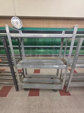 Aluminum mobile shelf cart with multiple tiers, sturdy frame, and caster wheels. Slightly worn; "Butter Only" mark visible.