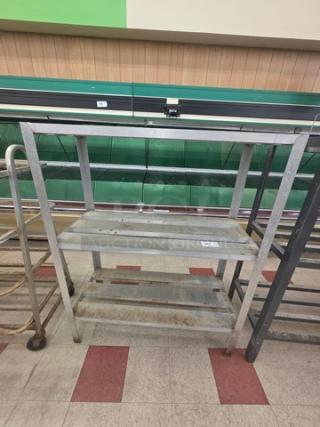 Aluminum shelf cart with three tiers, used condition, shows signs of wear, ideal for storage or transport.