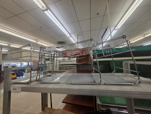 Lot of 4 metal T-shirt bag racks on a store shelf, in good condition. Suitable for retail use. Item numbers 214 and 215 visible.