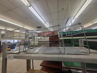 Lot of 4 metal T-shirt bag racks on a store shelf, in good condition. Suitable for retail use. Item numbers 214 and 215 visible.