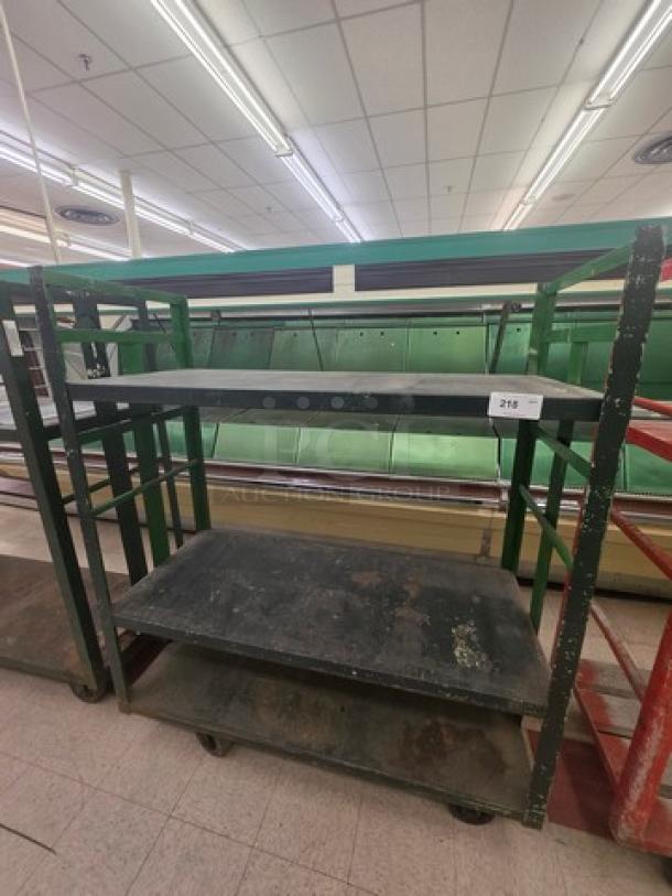 Industrial shelf cart with three metal shelves, worn green frame, and caster wheels. Label reads "218." Used condition.