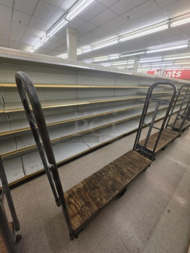 Industrial stock cart with metal frame and wooden platform, used condition. Ideal for warehouse or retail use.