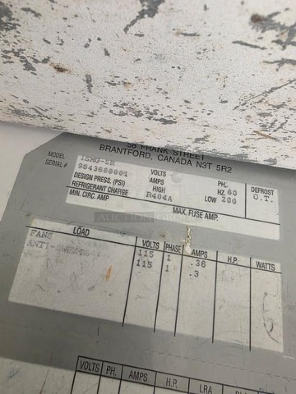 Label on Hussmann ISMG-5R Refrigerator showing model, serial number, refrigerant type R404A, and electrical specs.