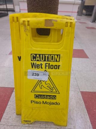 Lot of 3 yellow wet floor signs with "Caution Wet Floor" in English and Spanish, some wear, marked "239" for auction.