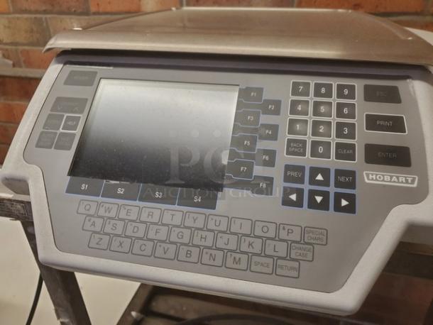 Hobart commercial hand wrap station with keypad and display, used condition, ideal for packaging tasks.