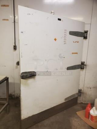 Eliason walk-in door with hardware, featuring visible hinges and handle. White surface with some wear marks.