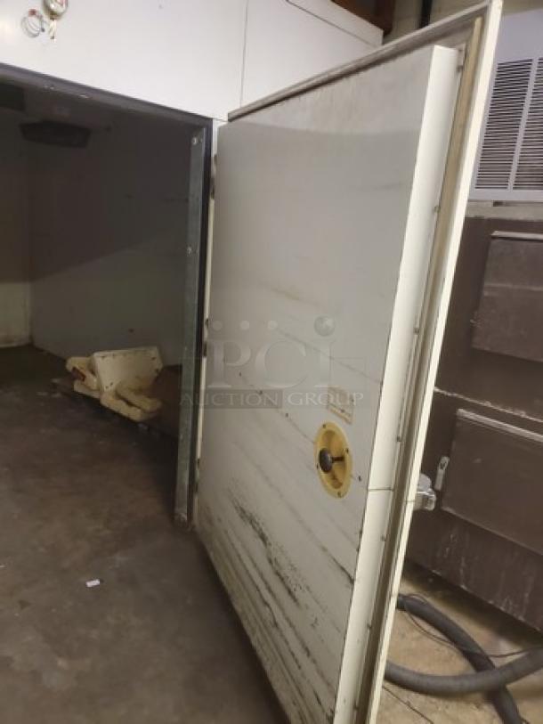 Eliason walk-in door with hardware, used condition, visible scuffs, includes label indicating manufacturer details.