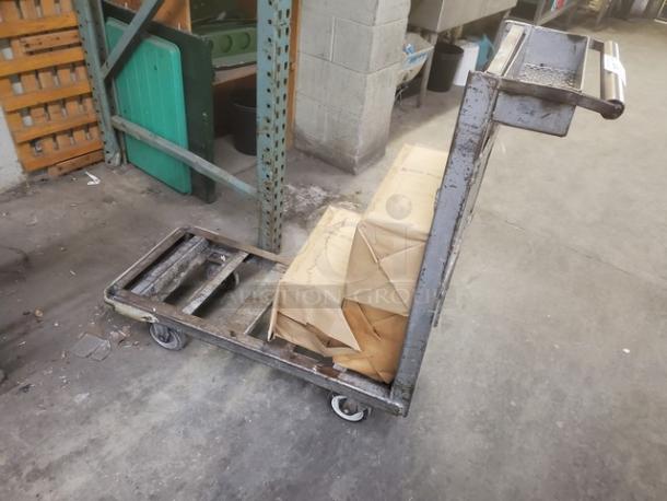 Sturdy retail dolly cart with steel frame and four wheels, carrying cardboard boxes. Ideal for warehouse transport. Good condition.