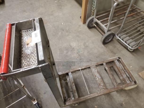 Metal retail dolly cart with perforated metal sides and red handle. Shows signs of wear. Tag reads "249".
