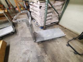 Stainless steel utility cart with handle, large platform, and swivel casters. Used condition, industrial design, sturdy construction.