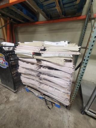 One pallet of used gondola shelving with multiple shelves stacked, showing some wear. Suitable for retail display.