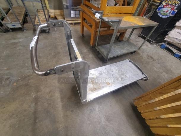 Metal utility cart with a sturdy handle and wheeled base. Appears used, with visible wear and scratches. Suitable for transport tasks.