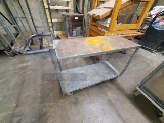 Metal utility cart, two shelves, signs of wear and rust. Sturdy handle, four wheels, industrial use, circa 48x24x36 inches.