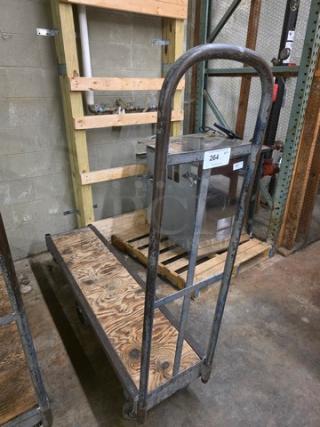 Metal stock cart with wooden platform, sturdy construction, four wheels, moderate wear. Label reads "264."