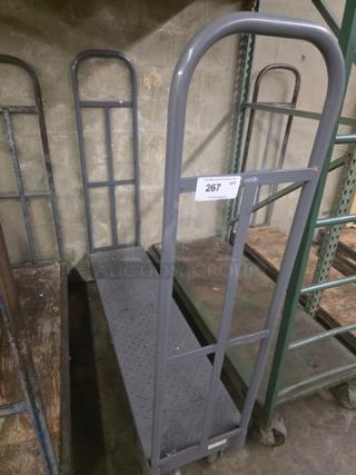 Gray stock cart with metal frame and diamond-patterned platform. Number 267 tag attached. Used condition, durable design.