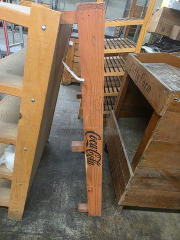 Set of wooden shelves, bench, and display bin. Shelves with visible Coca-Cola branding, display bin marked "Clifty Farm." Items show signs of wear, suggesting rustic appeal.