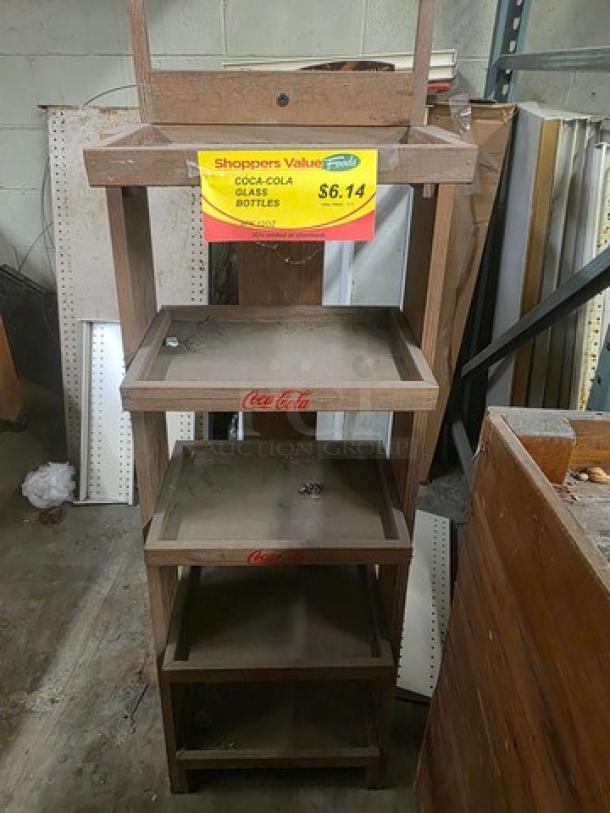 Wooden display bin with four shelves, featuring Coca-Cola branding. Used condition, price tag of $6.14 visible.