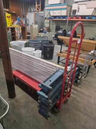 Red utility cart with tall handle, durable metal frame, four-wheel base. Surface shows wear; ideal for transporting materials.