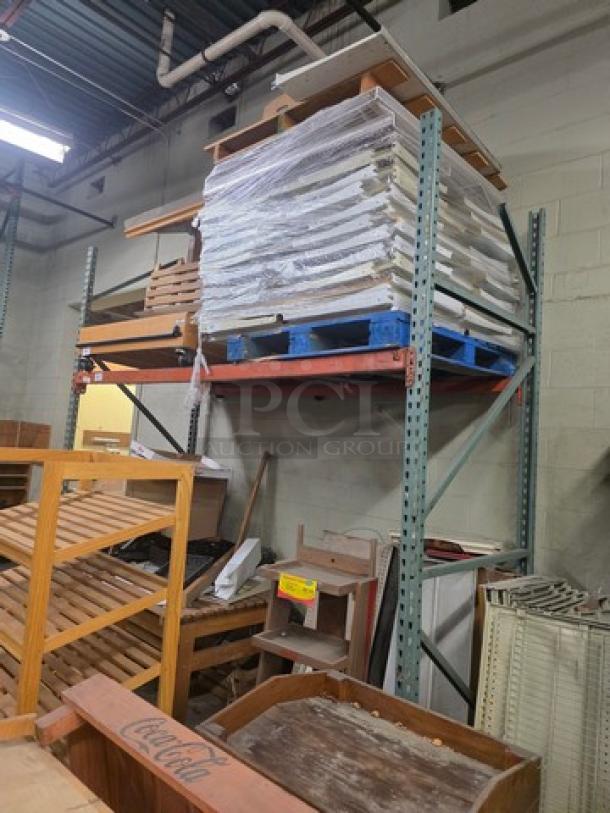 Steel pallet racks, two-tier, green beams, in warehouse setting. Contents not included. Good condition.