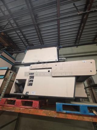 Supermarket checkout counter on pallets, beige finish, unknown condition, with buttons and display panel, labeled "3XBID."