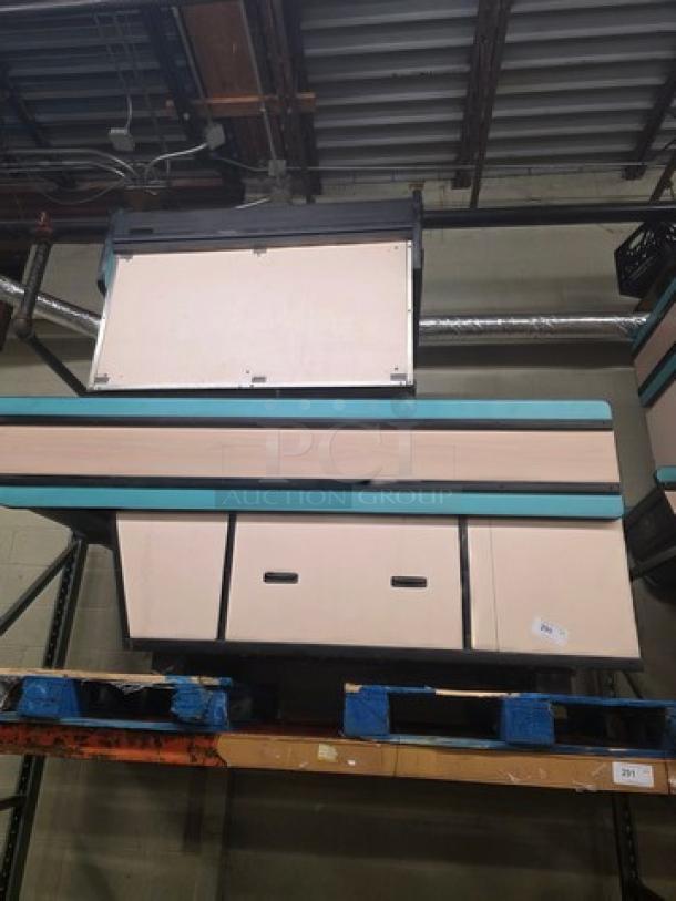 Supermarket checkout counter with storage cabinets, unknown condition, tagged "3XBID", on a warehouse shelf.