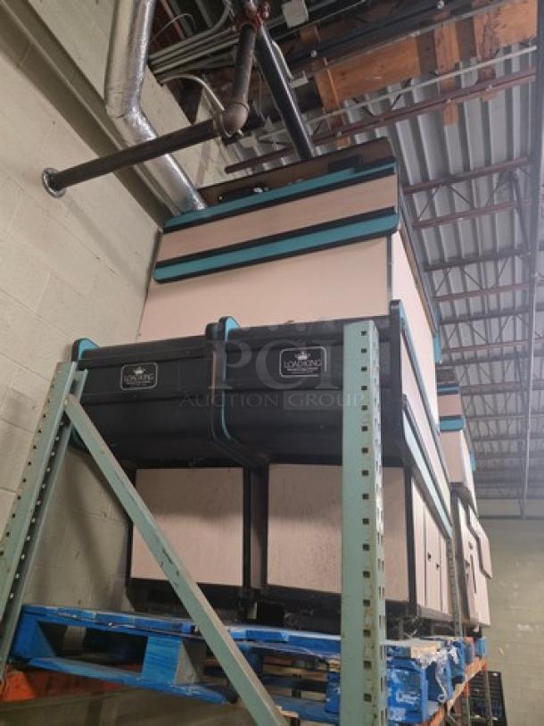 Supermarket checkout counter in unknown condition, stacked on pallets. Features black paneling and teal accents.