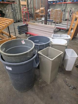 Lot of assorted trash cans in various shapes and sizes, good condition, gray and white colors. Some minor wear visible.