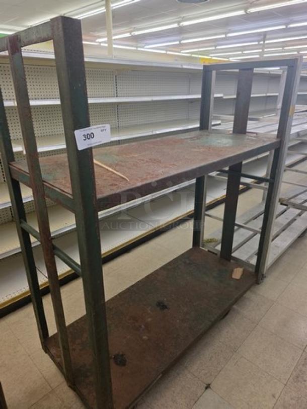 Heavy-duty mobile shelving cart, metal frame, two shelves, visible rust, in used condition. Auction lot tag "300".