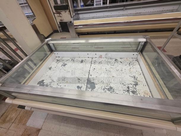 Hussmann ISMG-5R single-deck refrigerator island merchandiser, glass and metal finish, visible wear on base, fair condition.