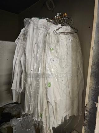 Lot of white butcher coats on hangers, plastic-wrapped, various sizes, excellent condition, visible tag with number 316.