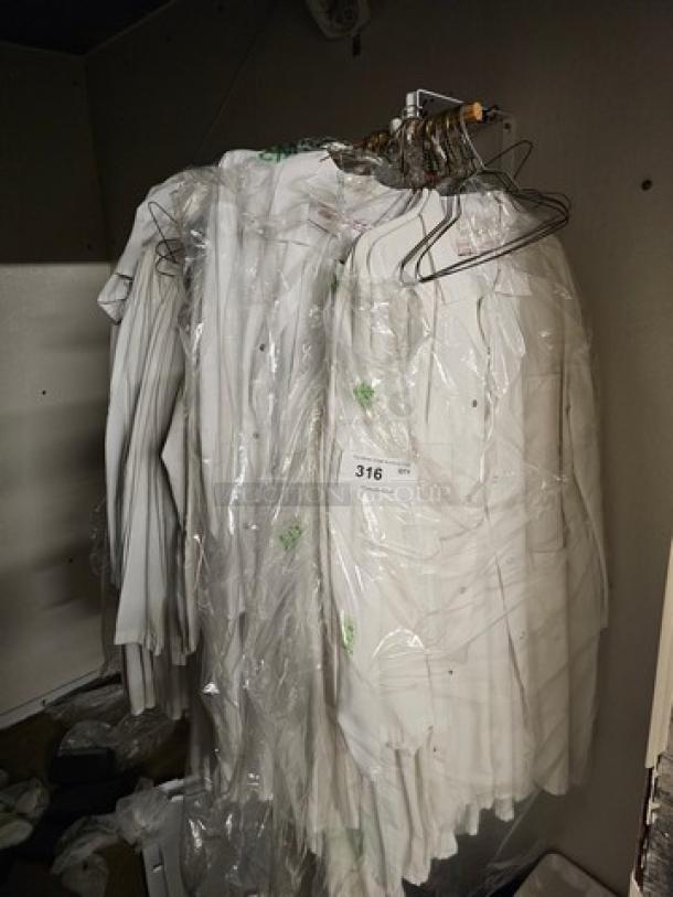Lot of white butcher coats on hangers, in plastic covering. Multiple items in good condition, labeled with lot number 316.