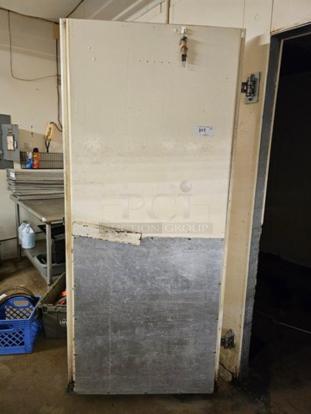 Walk-in door with hardware; beige and metal finish, minor wear. Includes latch and hinges. Ideal for commercial use.