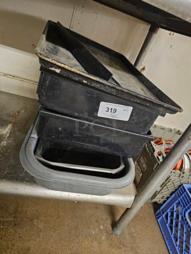 Lot of miscellaneous kitchenware, including black trays and pans. Visible label with number 319. Signs of wear.