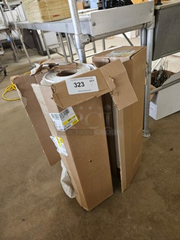 Rolls of plastic sheeting in partially opened cardboard box, showing labels with quantity and barcodes, in fair condition.