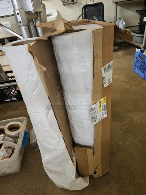 Two rolls of white plastic sheeting in open cardboard box, labels visible, showing new condition and large size.