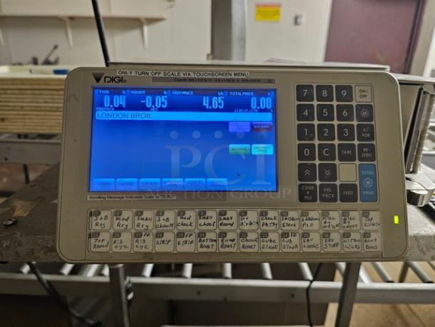 Digi SM5500a Manual Meat Wrapping Station with digital display, numeric keypad, and function buttons. Good condition.