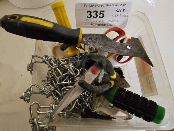 Lot of miscellaneous tools, including a scraper, pliers, scissors, and chains in a plastic container. Auction lot number 335.