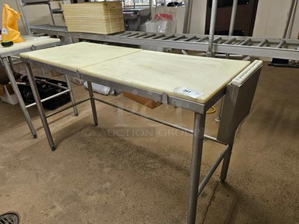 Stainless steel butcher block table with cutting board surface, sturdy condition, visible product tag with item number.