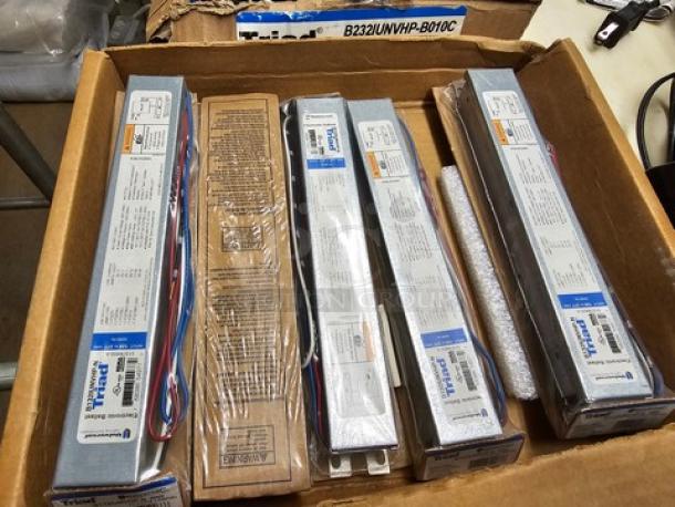 Two boxes containing Universal Triad B232IUNVHP-N electronic ballasts, brand new, with labels showing specifications.