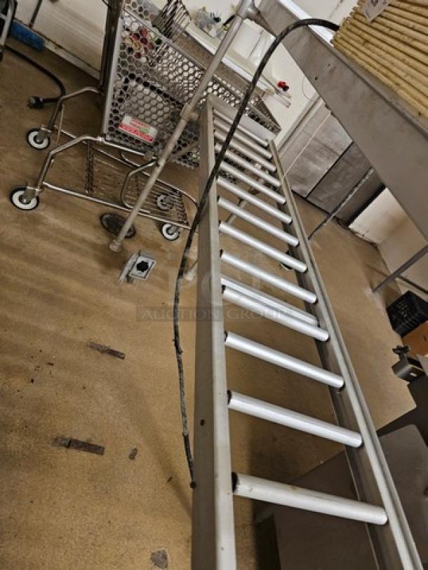 Stainless steel roller conveyor system in used condition, showing multiple aligned rollers. Buyer must safely remove.