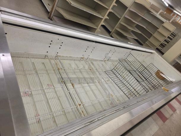 12' Hussmann LI-12U island case, stainless steel exterior, wire shelving, signs of use, suitable for retail display.