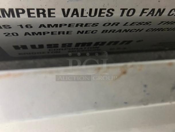 Close-up of Hussmann LI-12U label with amperage details. Slight wear visible, indicating typical usage for an island case.