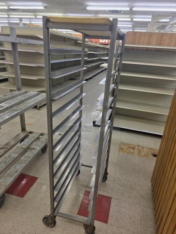 Mobile sheet pan rack with ten slots, metal construction, on caster wheels for easy mobility, in used condition.