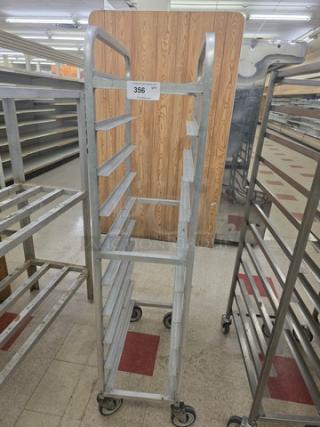 Mobile sheet pan rack with multiple shelves, metal construction, on wheels for easy transport. Number tag 356 visible.